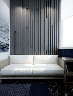 a white couch sitting in front of a wall with wooden paneling on it's sides