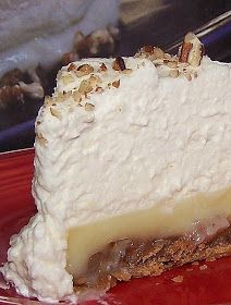 a piece of cheesecake on a red plate with pecans around the edges and toppings