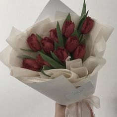 a person holding a bouquet of red flowers