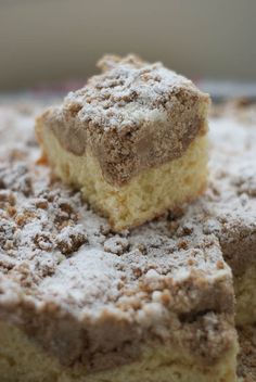 two pieces of cake sitting on top of each other with powdered sugar on them