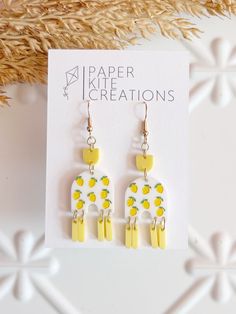 White acrylic with hand painted lemon. Yellow accent beads. Gold fishhook style post.  Length: 2 inches Width: .75 inches Adjustable Hand Painted Yellow Jewelry, Adjustable Yellow Hand-painted Jewelry, Adjustable Yellow Hand Painted Jewelry, Fun Hand Painted Yellow Earrings, Fun Yellow Hand Painted Earrings, Artsy Yellow Jewelry With Ear Wire, Hand Painted Yellow Polymer Clay Jewelry, Hand-painted Yellow Polymer Clay Jewelry, Hand Painted Yellow Earrings For Summer