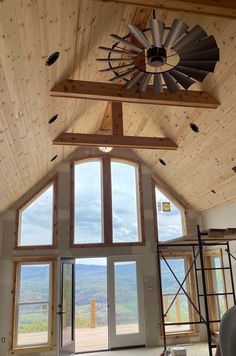 the inside of a house that is being built with wood paneling and large windows