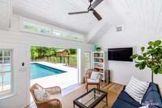 a living room filled with furniture next to a swimming pool