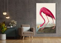 a pink flamingo standing on top of a wooden floor next to a gray wall