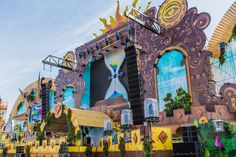 an outdoor stage set up for a concert with colorful decorations on the sides and large windows