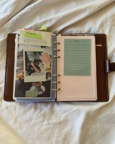 an open planner book sitting on top of a bed