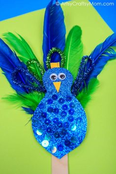 a blue bird with green feathers is on a toothpick made from plastic beads