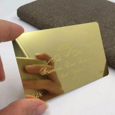 a person holding up a gold business card