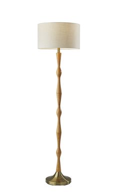 a wooden floor lamp with a white shade on the base and a gold metal base