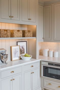 a kitchen with white cupboards and an oven in it's center island area