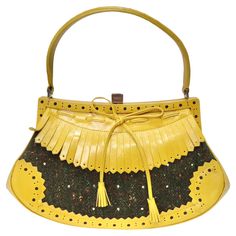 Elevate your accessory game with the Moschino Vintage Yellow Leather Tweed Handbag – a true gem from the past that showcases a delightful fusion of colors and textures. This vintage Moschino handbag is more than just an accessory; it's a work of art that exudes timeless charm and creativity. The standout feature of this handbag is the yellow leather fringe and the eye-catching bow motif at the center. This playful and vibrant detail immediately captures attention and sets this bag apart from the Moschino Vintage, Tweed Handbag, Moschino Bag, Vintage Moschino, Gucci Boots, Structured Shoulder, Green Tweed, Retro Bags, Moschino Logo