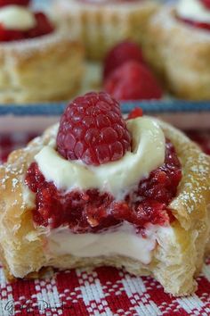 raspberry cream filled pastries on a red and white checkered table cloth