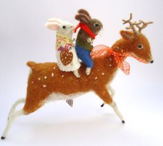 a stuffed animal riding on the back of a deer