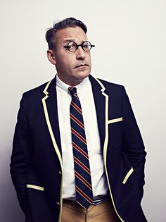 a man in a suit and tie is posing for a photo with his hands on his hips