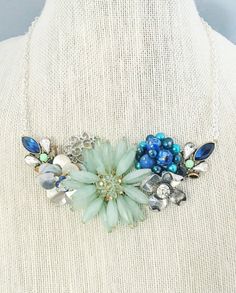 This is a gorgeous one of a kind necklace handmade from pieces and parts of other jewelry, some vintage and some newer.The blues range from turquoise to royal blue, with light green as well. There are rhinestones and shells.  The chain is 14 inches long. Unique Handmade Flower Jewelry For Wedding, One Of A Kind Blue Jewelry For Wedding, Unique Blue Jewelry For Wedding, Blue Flower Decorated Jewelry For Wedding, Blue Wedding Jewelry With Flower Decoration, Blue Flower Decorated Wedding Jewelry, Blue Flower Wedding Jewelry, Blue Flower Necklace For Wedding, Recycled Necklaces