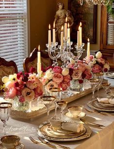 a dining room table is set with flowers and candles for an elegant dinnereonal