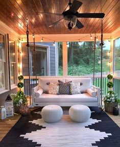 a white couch sitting on top of a black rug under a wooden ceiling with lights