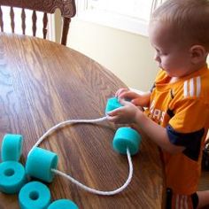 a young boy is playing with toys on the table