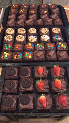 two trays filled with chocolate covered cookies and strawberries