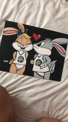 someone is holding up a card with an image of two rabbits kissing each other on it