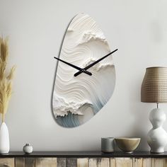 a clock that is on the wall next to a lamp and table with vases