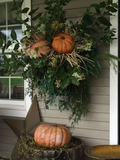 two pumpkins sitting on top of a wooden barrel next to a window sill