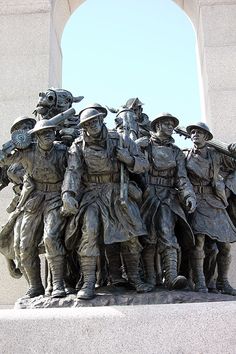 a group of men standing next to each other in front of a monument