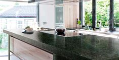 a large kitchen with an island counter top and black granite counterstop, along with glass doors leading to the outside patio