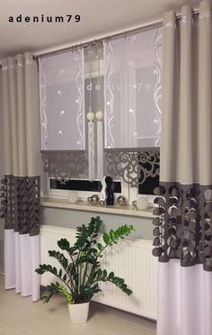 the kitchen is decorated with white curtains and grey drapes, along with a potted plant