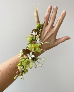 a person's hand with flowers on it and two hands reaching out to each other