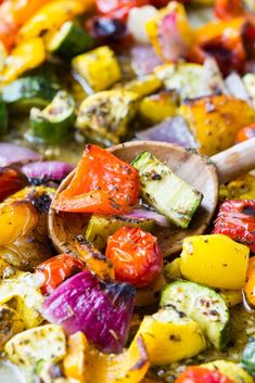 a pan filled with grilled vegetables and a wooden spoon