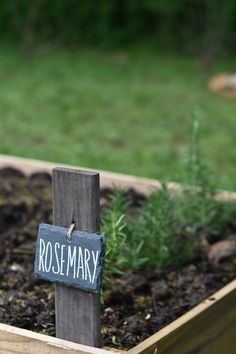 a wooden box filled with dirt and grass next to a sign that says easy garden markers