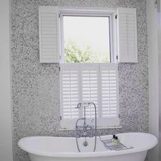 a white bath tub sitting under a window