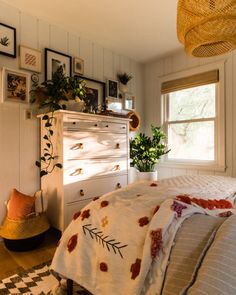 a bedroom with an unmade bed and lots of pictures on the wall above it