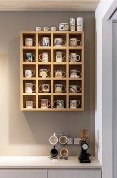 a shelf with coffee cups on it and a clock mounted to the wall behind it