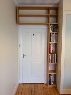 an empty room with bookshelves and a door