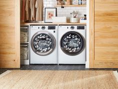 two washers are sitting side by side in the laundry room