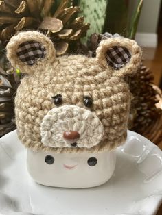 a crocheted bear hat sitting on top of a white cup