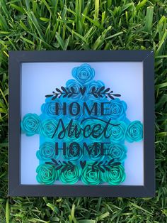 a frame that has some flowers in it and the words home sweet home on it