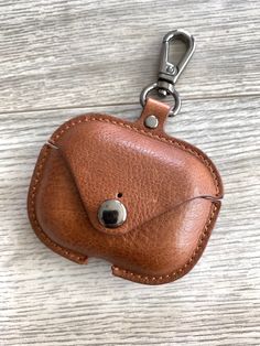 a brown leather case with a metal keychain hanging from it's side