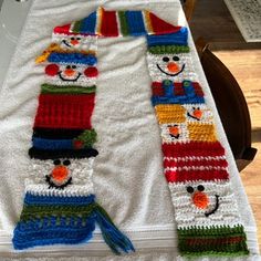 two crocheted snowmen sitting on top of a table