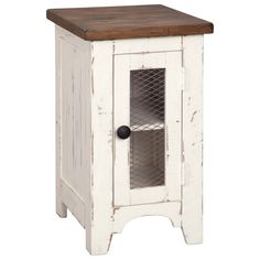 an old white cabinet with a wooden top and metal mesh inserts on the door