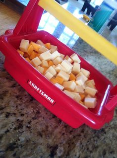 a red container filled with cubes of food on top of a counter next to a yellow plastic fork