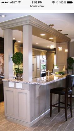 a large kitchen with an island in the middle and two bar stools at the end