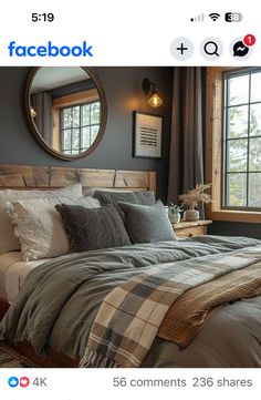 a bed with pillows and blankets on top of it in front of a large window