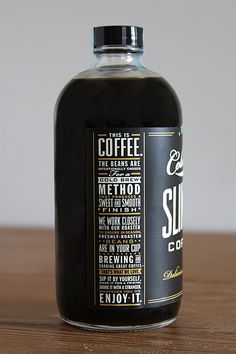 a bottle of coffee sitting on top of a wooden table