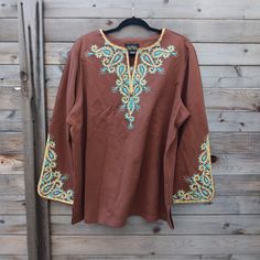 This Beautifully Embroidered Tunic Has It Along The Neckline And Sleeve Cuffs. With The Intertwining Of The Blues, Golds, And Browns It Most Definitely Brings Art Onto The Fabric. Traditional Brown Tops For Fall, Traditional Embroidered Brown Tops, Fabric Artwork, Western Blouse, Blue Denim Shirt, Embroidered Tunic Top, Sleeveless Knit Top, Sequin Shirt, Bob Mackie