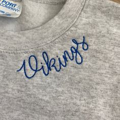 a close up of a shirt with writing on the front and back, in blue ink