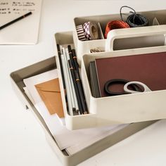 an organized drawer with scissors, pencils, and other office supplies on the table