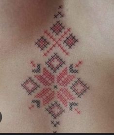 a cross stitch pattern on the back of a woman's chest is seen in this image